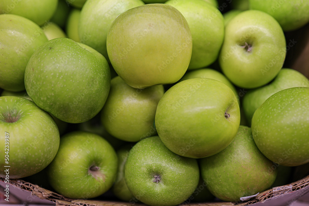 Green apples in the cardboard boxes on the supermarket shelf Green apples in the cardboard boxes on the supermarket shelf