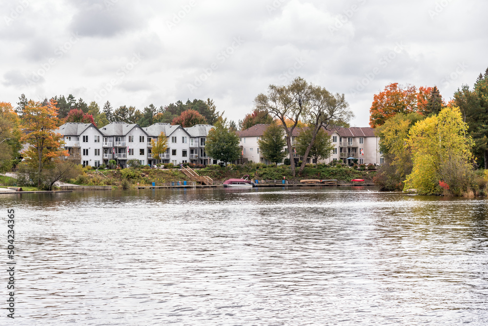 Modern waterfront condos along the shore of a lake on a cloudy autumn day