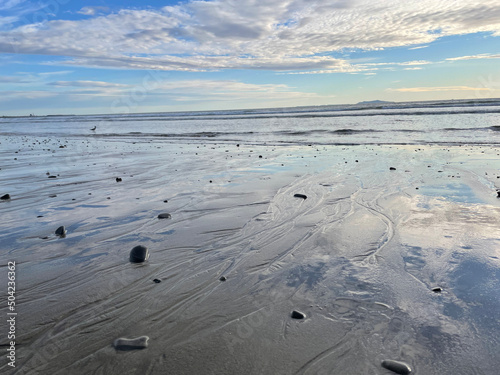 Ventura Beach with sky reflecting in sand