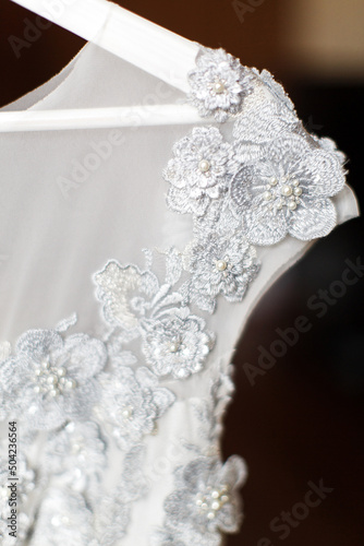 Fototapeta Naklejka Na Ścianę i Meble -  Wedding dress hanging in the room, close-up