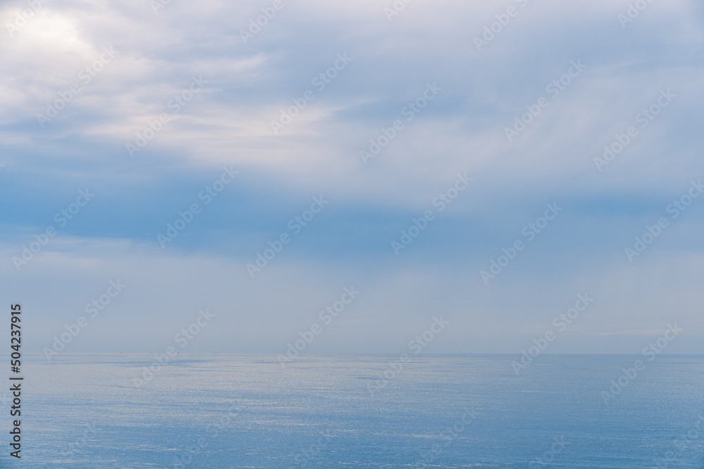 Blue sea and sky horizon with clouds