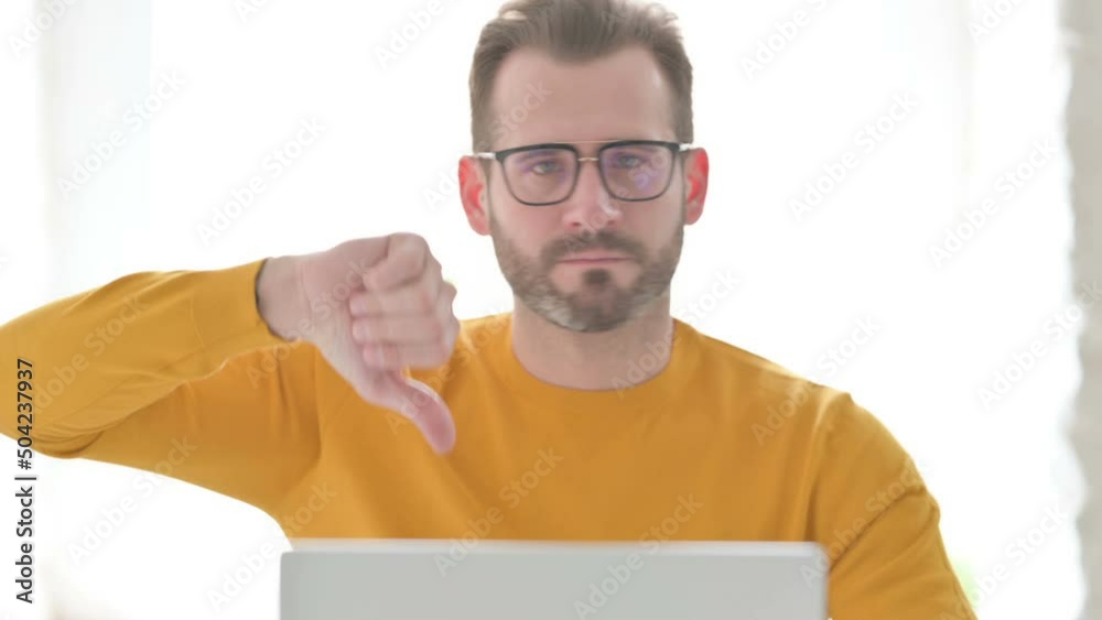 Portrait of Man with Laptop Showing Thumbs Down Portrait of Man with Laptop Showing Thumbs Down