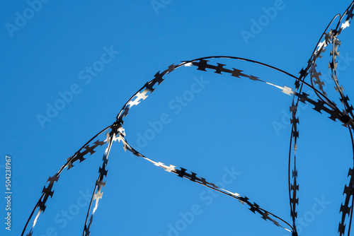 Barbed wire against clear blue sky. Copy space for text