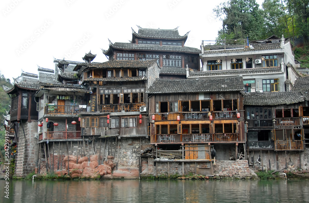 Fenghuang, Hunan Province, China: Old wooden riverside houses in Fenghuang ancient town. The town is built on the Tuojiang River and is home to Miao and Tujia minority peoples.