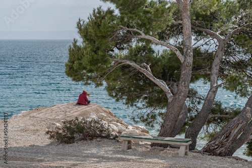 Lone female sitting on the edge of the beach