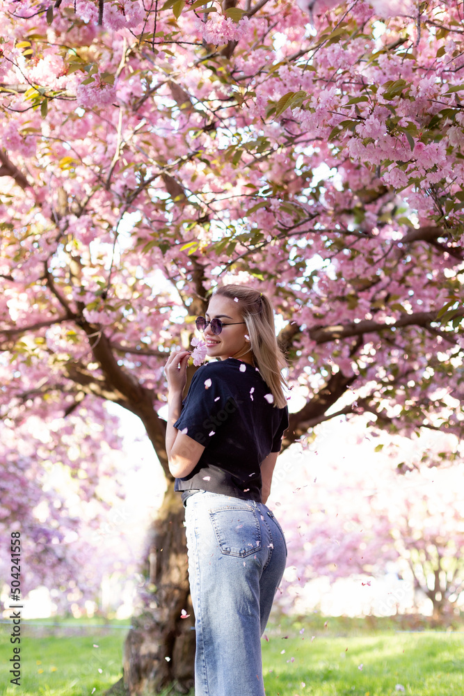 Beautiful girl in sunglasses on the background of flowering sakura trees. Beautiful girl in sunglasses on the background of flowering sakura trees.
