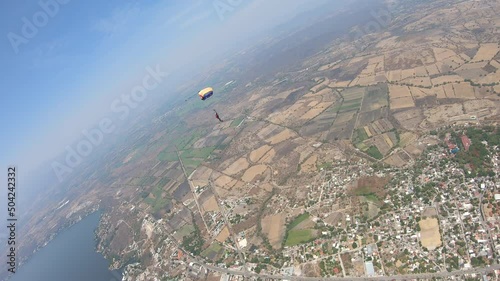A color parachute is flying in the sky. The view from another parachute. 