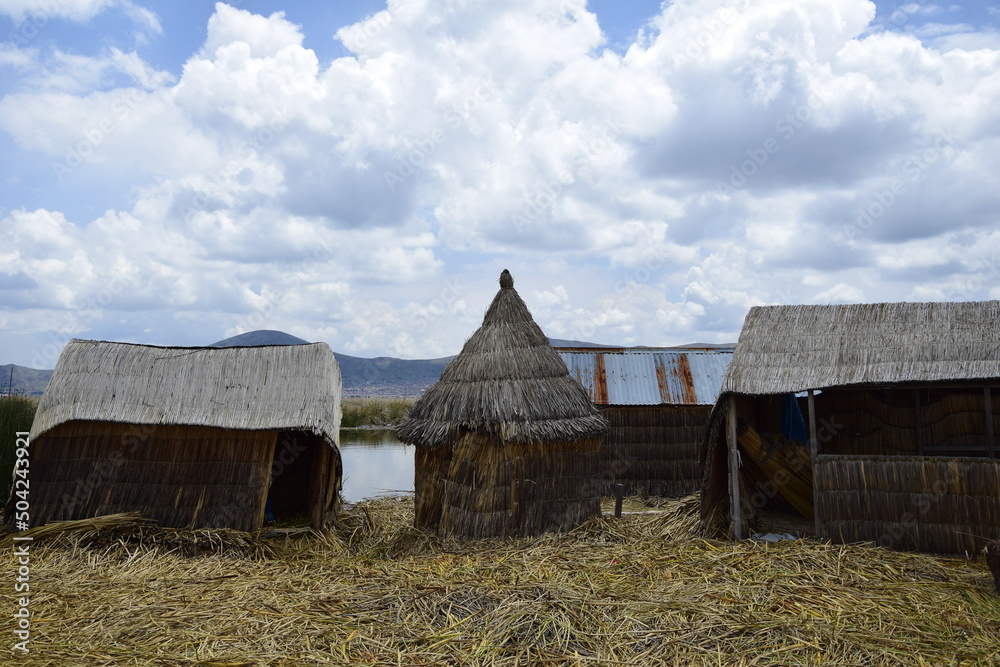 Floating islands near Puno city, Buildings and houses made of straw on the floating islands of Lake Titicaca. Puno, Peru Floating islands near Puno city, Buildings and houses made of straw on the floating islands of Lake Titicaca. Puno, Peru