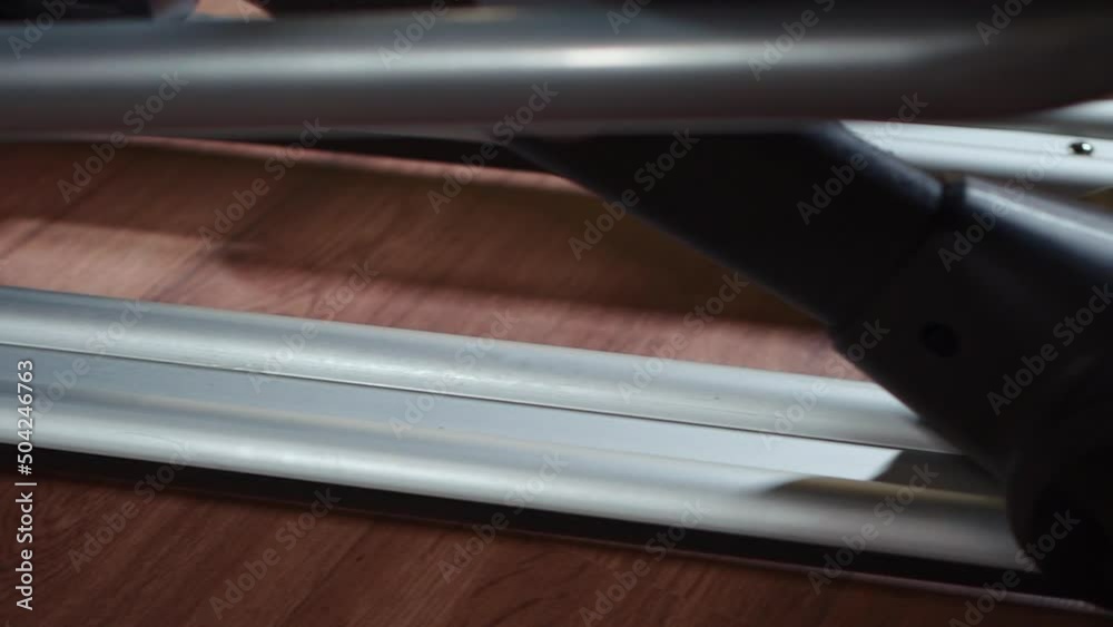 close up of sliding on elliptical machine parts, deck, roller, magnetic rail close up of sliding on elliptical machine parts, deck, roller, magnetic rail