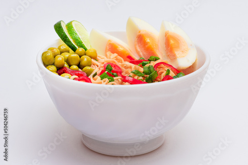 Beautiful Noodle Dish with Green Pea, Eggs, Red Hot Pepper, Greens and Lime on White Background. Instant Noodles