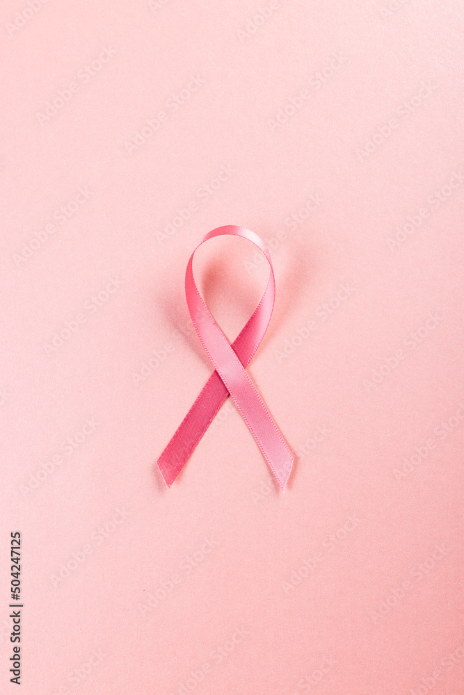 Directly above shot of pink breast cancer awareness ribbon isolated over pink background, copy space Directly above shot of pink breast cancer awareness ribbon isolated over pink background, copy space
