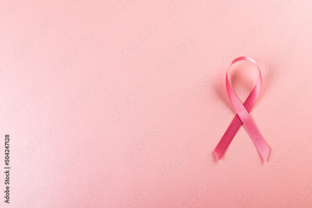 Directly above shot of pink breast cancer awareness ribbon over pink background, copy space Directly above shot of pink breast cancer awareness ribbon over pink background, copy space