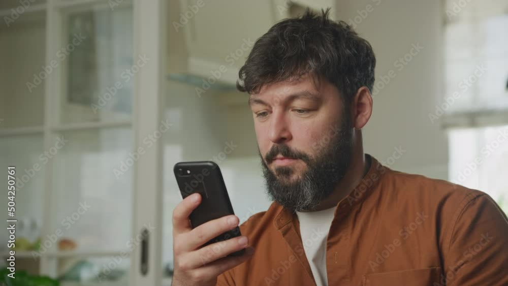 Young adult caucasian man browsing on his smartphone indoors