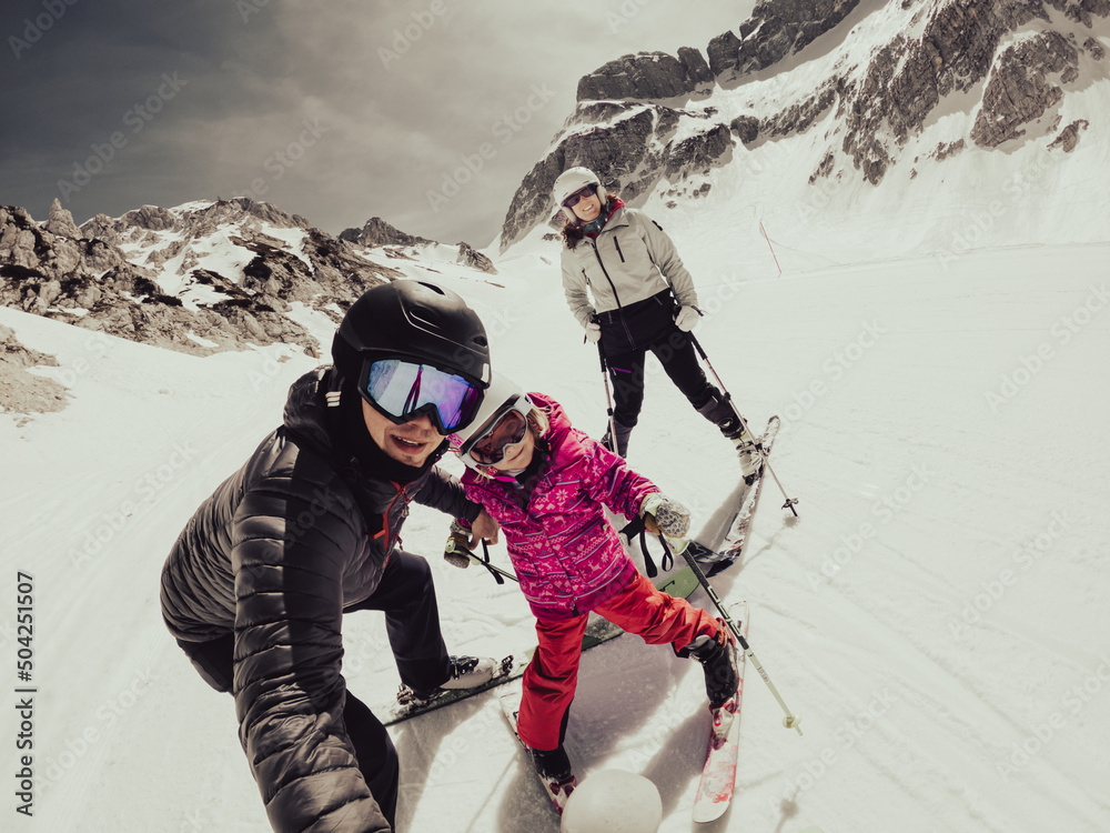 Happy young family taking a selfie at skiing resort.