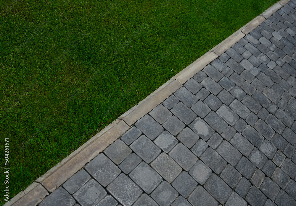 The curb along the edge of the walkway is flush with the paving