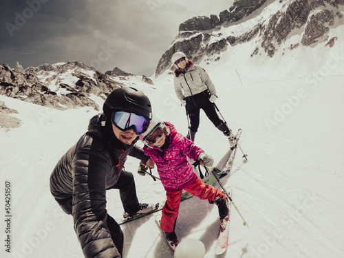 Happy young family taking a selfie at skiing resort.