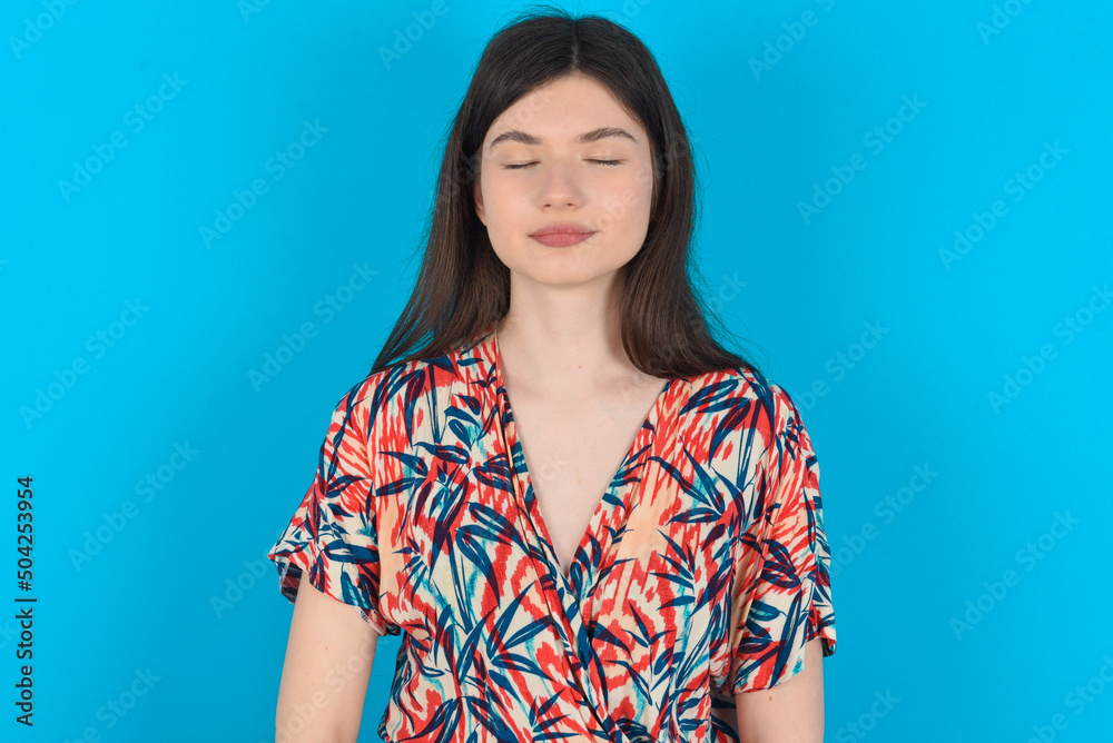 young caucasian woman wearing floral dress over blue background nice-looking sweet charming cute attractive lovely winsome sweet peaceful closed eyes young caucasian woman wearing floral dress over blue background nice-looking sweet charming cute attractive lovely winsome sweet peaceful closed eyes