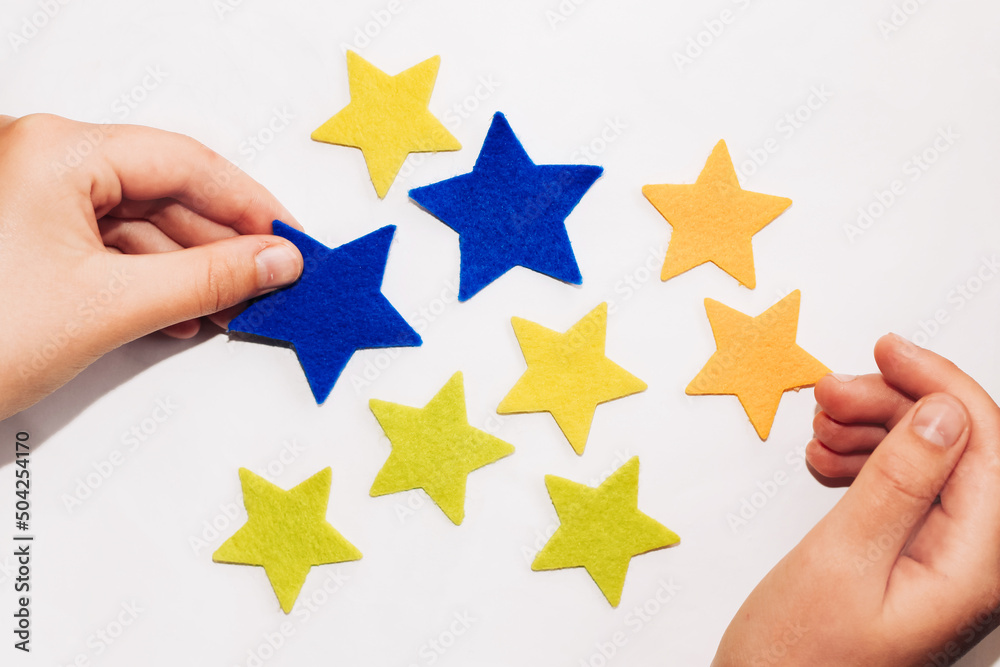 Application of felt stickers of stars in the colors of the blue-yellow Ukrainian flag. Application of felt stickers of stars in the colors of the blue-yellow Ukrainian flag.