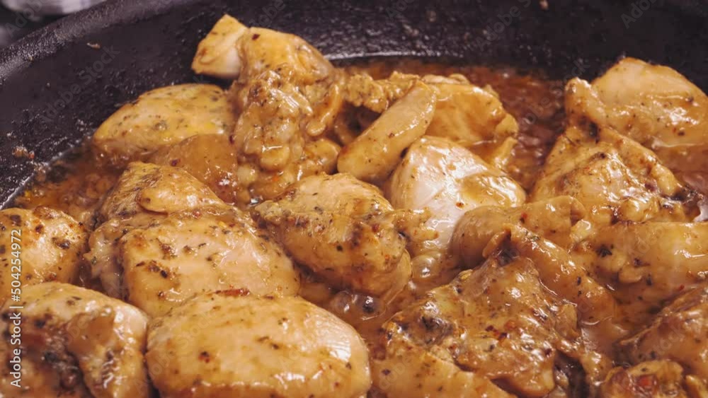 Chicken pieces in sauce are fried in boiling oil in a frying pan. close-up Chicken pieces in sauce are fried in boiling oil in a frying pan. close-up