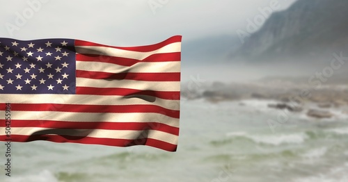 Composite image of waving american flag against landscape with sea and mountains