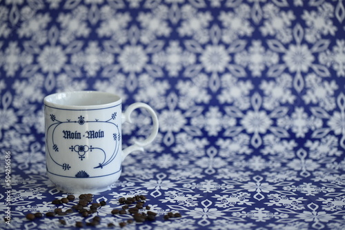 Kaffee in einer blau-weißen Tasse mit Kaffeebohnen