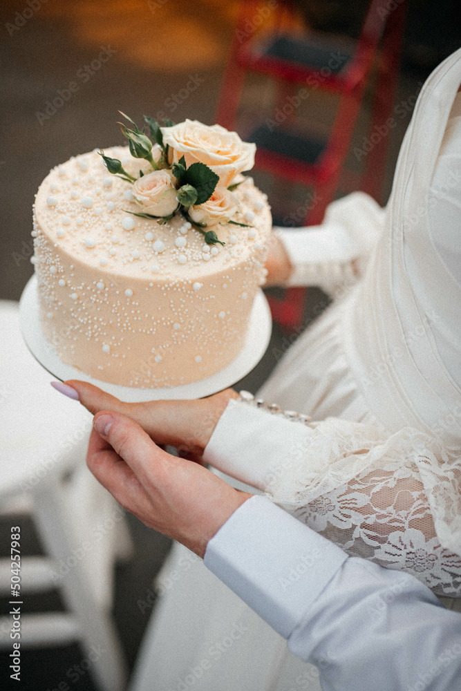bride and groom holding wedding cake bride and groom holding wedding cake