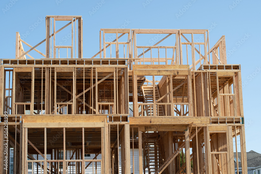 New residential construction home framing against a blue sky