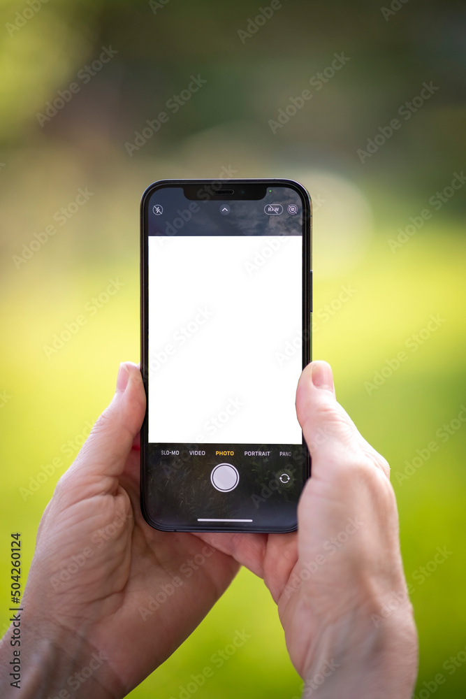 Elderly hands holding phone with blank screen and taking pictures 