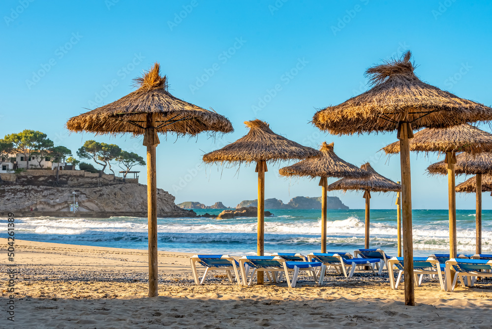 Fototapeta premium deserted morning sea beach with sunny screens. Platja Palmira