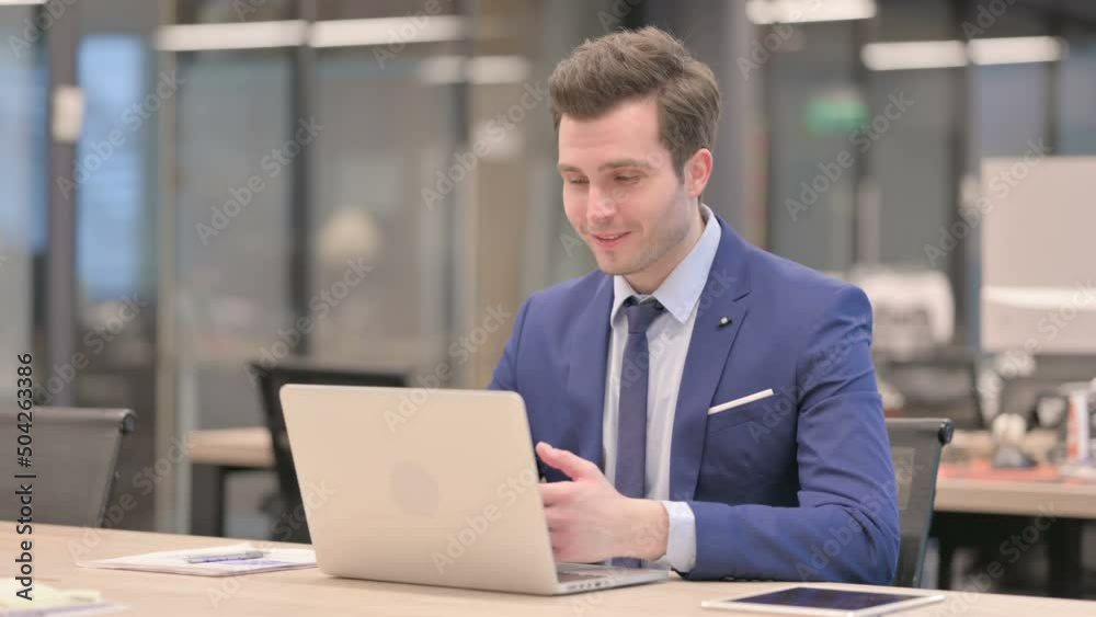 Businessman Talking on Video Call on Laptop in Office
