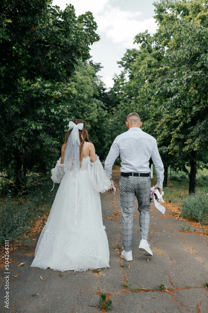 bride and groom walking in the park