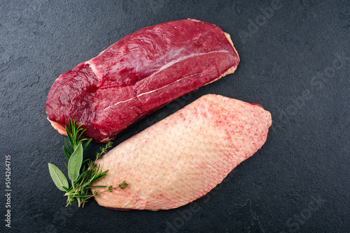 Obraz na plátne Traditional raw gourmet duck breast filet with skin offered with herbs as top vi