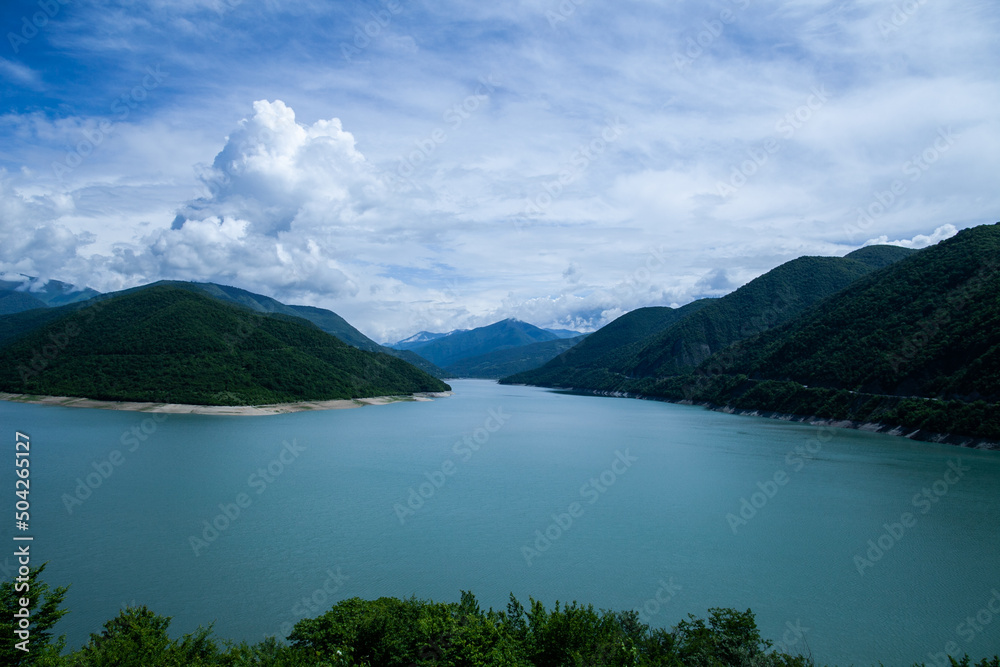 landscape with lake, mountains, clouds in daylight, in blue tones, general plan, front view