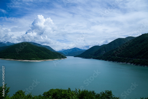 landscape with lake, mountains, clouds in daylight, in blue tones, general plan, front view