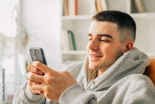 teen boy at home with cellphone or smartphone