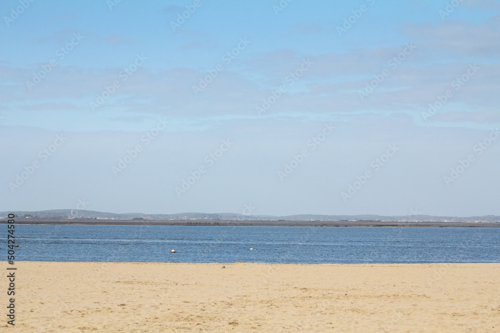 Panorama of a beach on the atlantic ocean, on arcachon waterfront, on the bassic d'arcachon bay, during a sunny afternoon, with a blue sky, in Aquitaine, france...