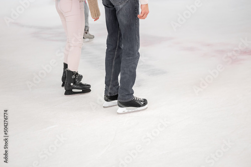 Legs of a man and woman skating on an ice rink. Winter holidays leisure © jockermax3d