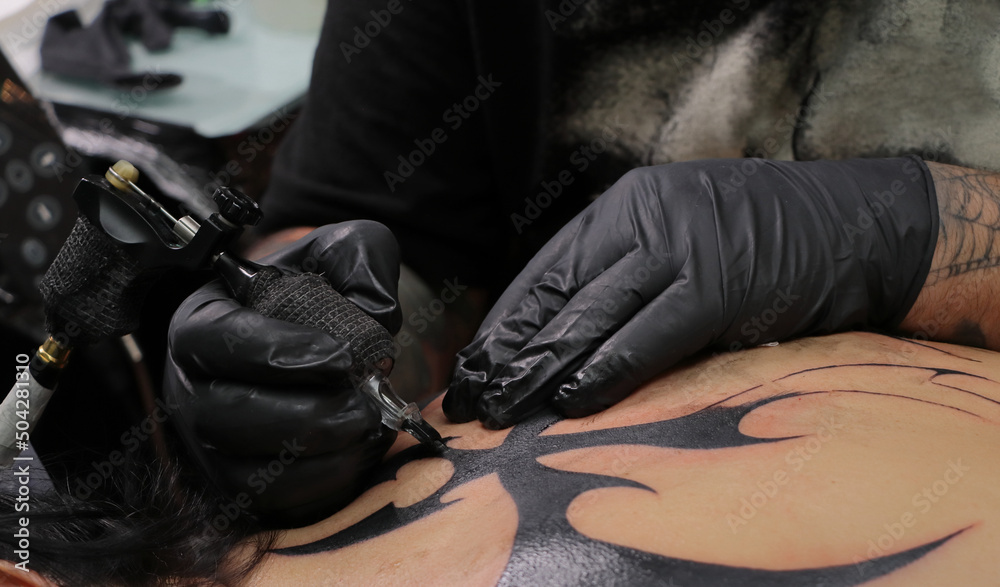 Tatuador en sesión de tatuaje tatuando un tatuaje a una persona