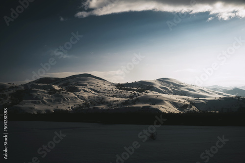 Landscape view of a mountain with snow, blue sky and some clouds