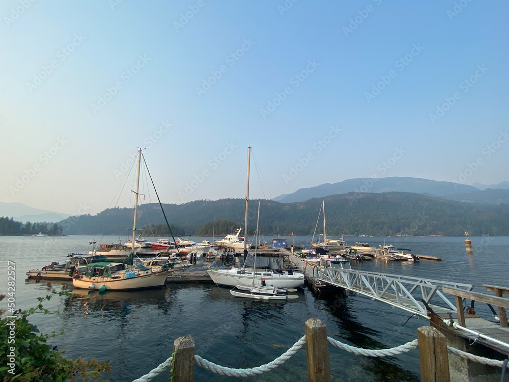 Sailboats at a marina with mountains in the background and blue skies, Egmont, northern British Columbia, Canada
