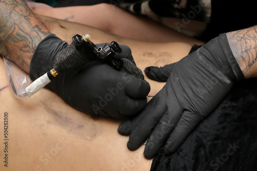 Tatuador en sesión de tatuaje tatuando un tatuaje a una persona