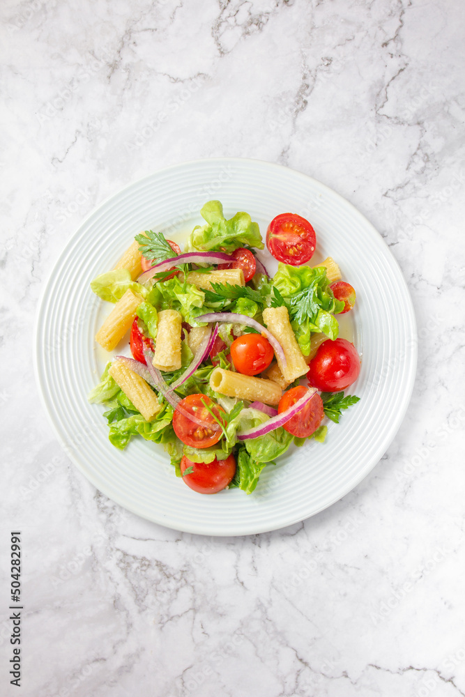 Lettuce tomato cherry salad with penne pasta.