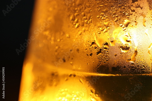 Fotografie Amber back lighted frosty glass with drink, close up macro image photograph