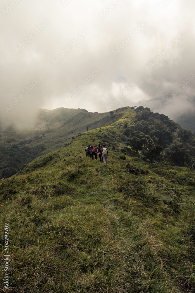Obraz premium vertical shot of a group of hikers on a hill in the green mountains of Costa Rica