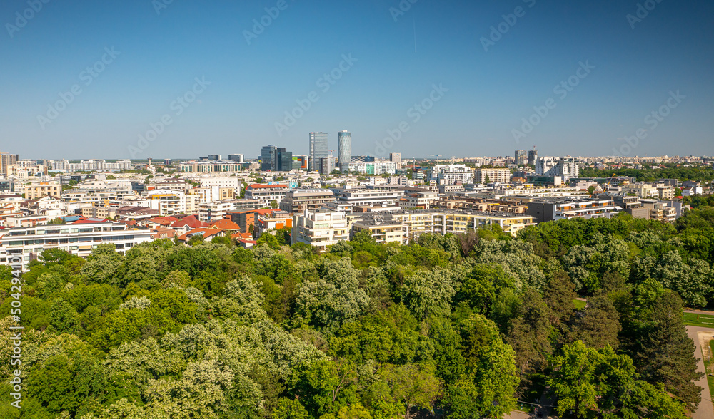 Bucharest from above, aerial view over Herastrau (King Michael I) Park, lake and the north part of the city with office building photographed during a summer sunny day.