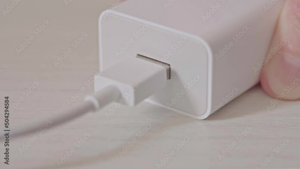 Inserting a USB connector into the charger port close up. USB connector system or connection interface in hand on white background. Connecting USB cable into a charger plugged. High quality 4k footage Inserting a USB connector into the charger port close up. USB connector system or connection interface in hand on white background. Connecting USB cable into a charger plugged. High quality 4k footage