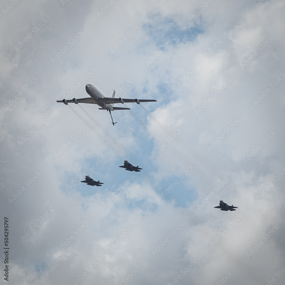 Fototapeta premium Three Israeli Stealth Fighter Jets Flying in Formation together with a Refueling Jumbo Jet in the air parade as part of Israel's Independence Day Celebrations