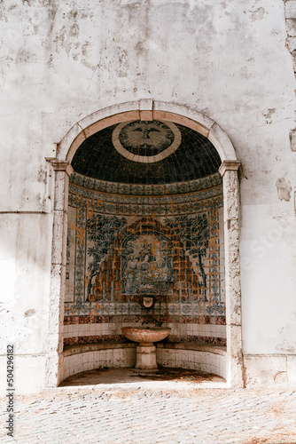 Slika na platnu A beautiful alcove along an ancient building with hand painted mosaic and water fountain in Lisbon, Portugal