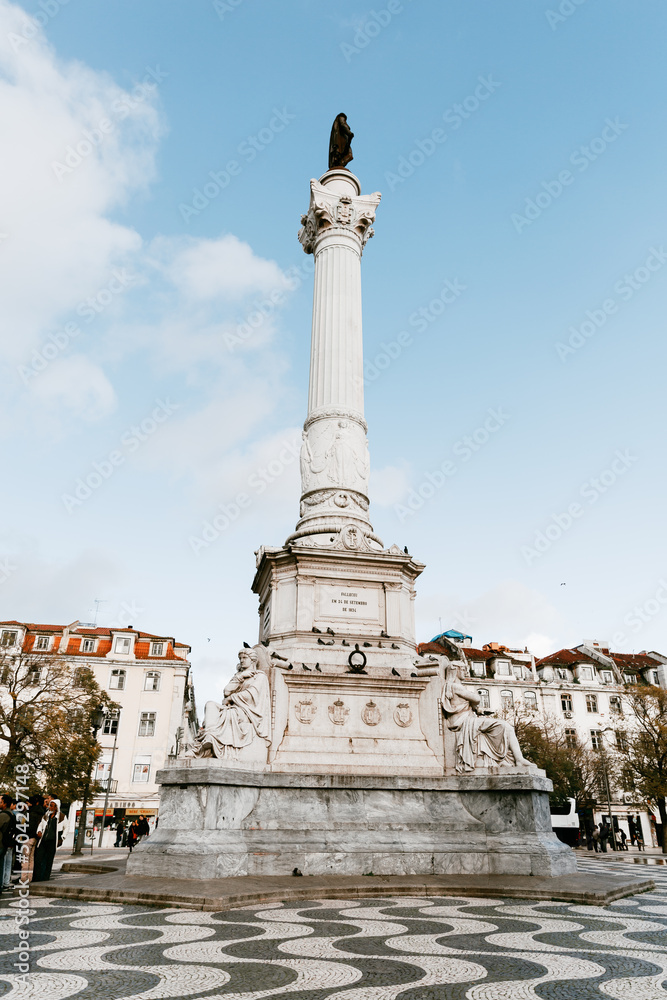 Praca do Rossio plaza square in Lisbon Portugal that is famous for its black and white rolling motion square mosaic, tourism, cafes, and Column of Pedro IV. 