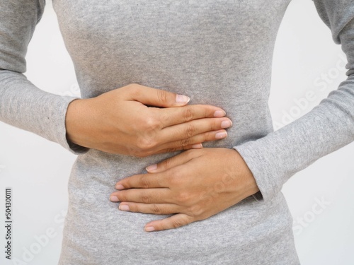 Woman with stomach pain causes of abdominal pain include inflammatory bowel disease-IBD. stomach ulcer irritable bowel syndrome (IBS), ulcerative colitis and microvilli. closeup photo, blurred. photo